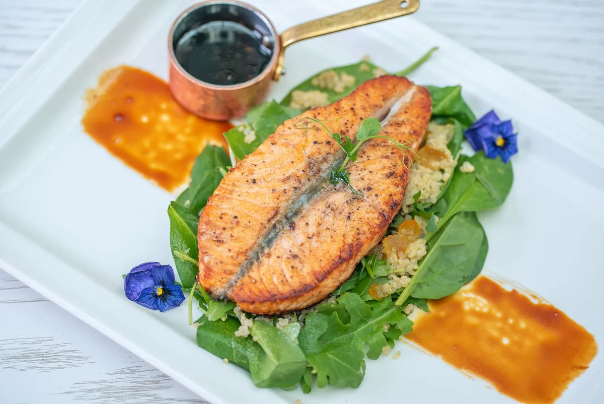 Bol de quinoa avec saumon grillé, épinards et graines de courge