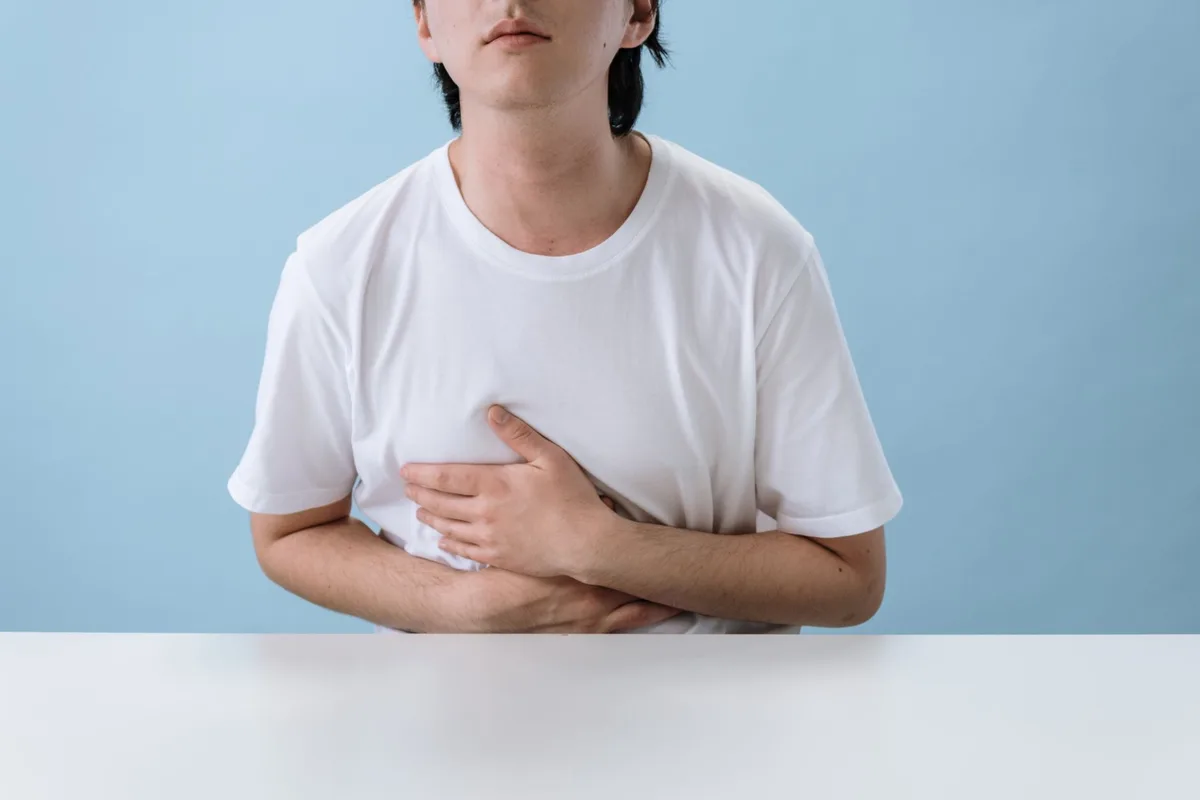 Personne se tenant l'abdomen, illustrant l'inconfort gastro-intestinal
