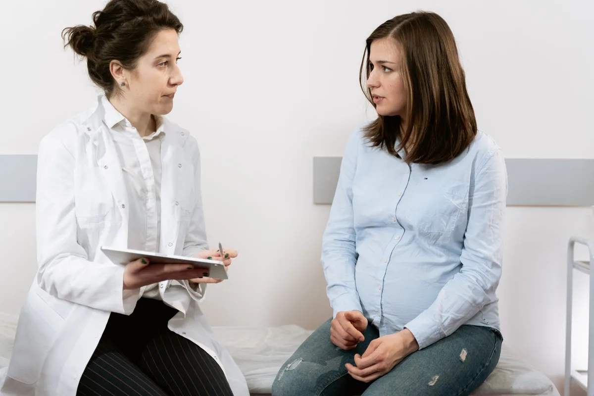 Femme enceinte en consultation médicale avec un professionnel de santé