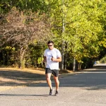 Coureur et cycliste en action côte à côte sur un sentier ensoleillé, comparaison d'intensité physique.