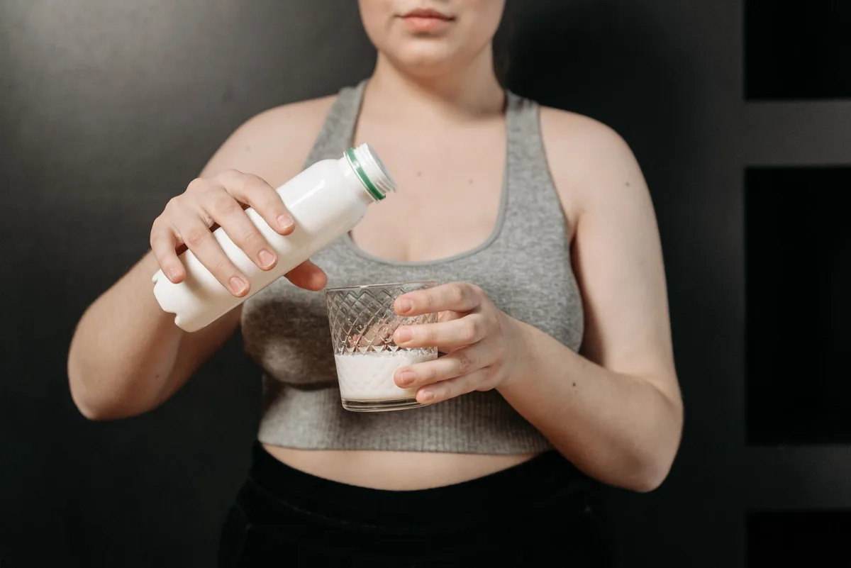 Gros plan sur le lait versé dans un verre pour vérifier son apparence et sa texture