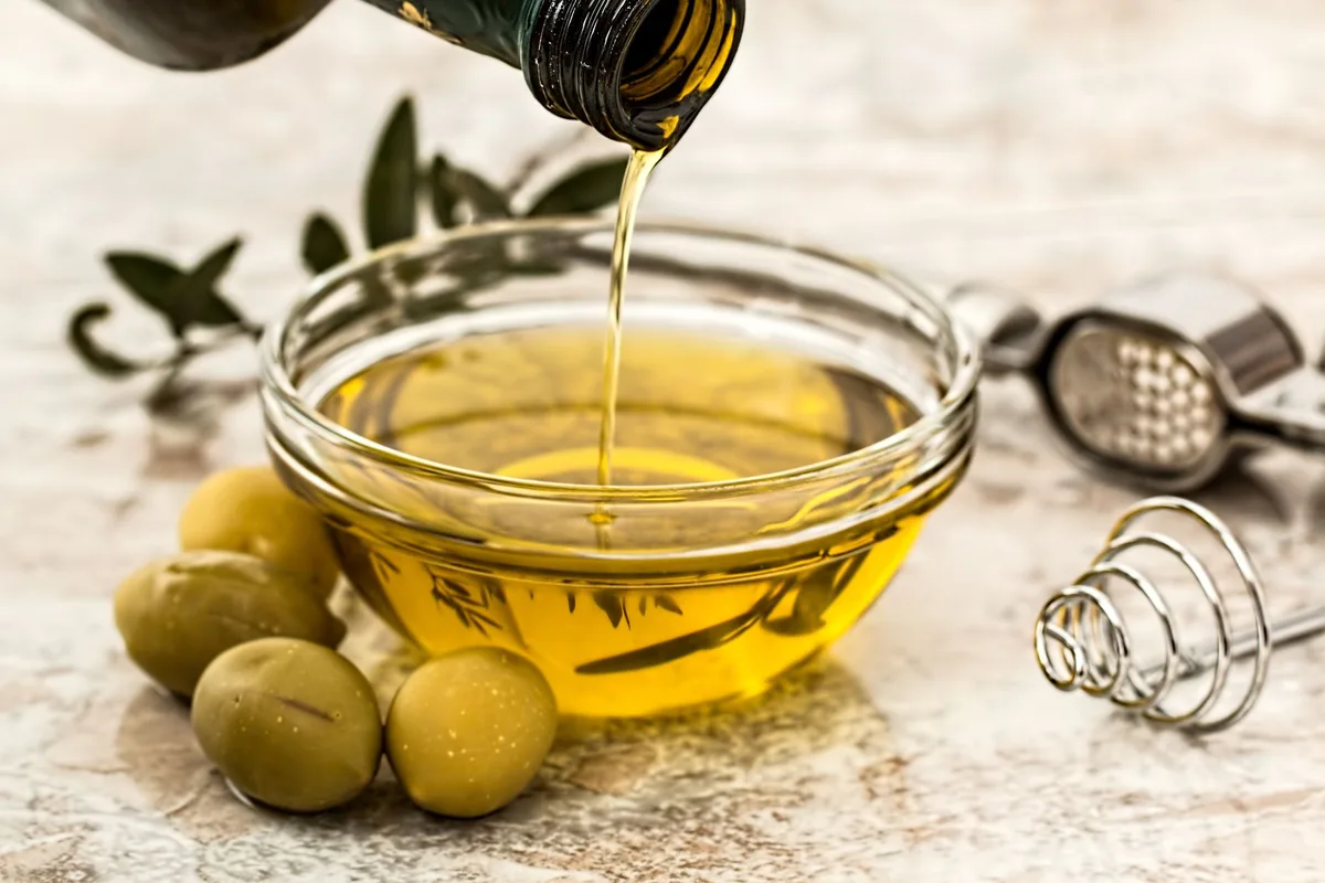 Huile d'olive extra-vierge versée sur des légumes pour améliorer l'absorption des nutriments