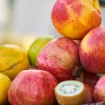 Aliments frais anti-âge : baies, légumes verts, poisson gras et huile d'olive sur un plan de travail