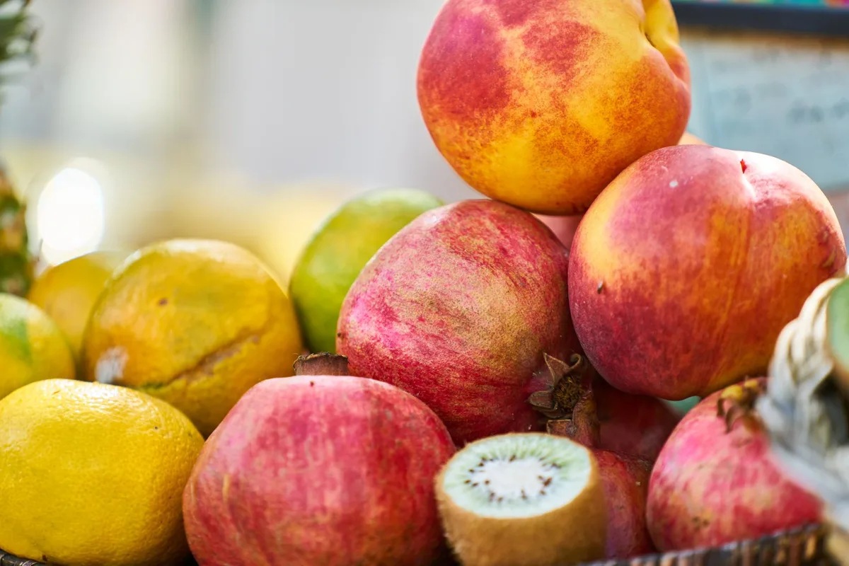 Aliments frais anti-âge : baies, légumes verts, poisson gras et huile d'olive sur un plan de travail