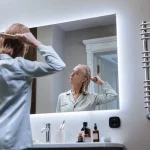 Femme examinant ses cheveux devant un miroir de salle de bain, préoccupée par une possible chute