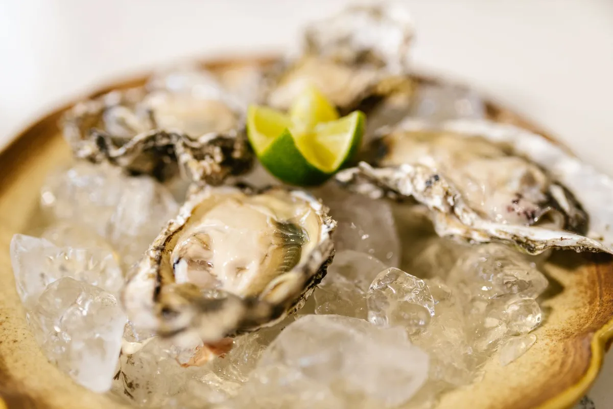 Aliments riches en zinc : huîtres, viande, graines et légumineuses sur une table