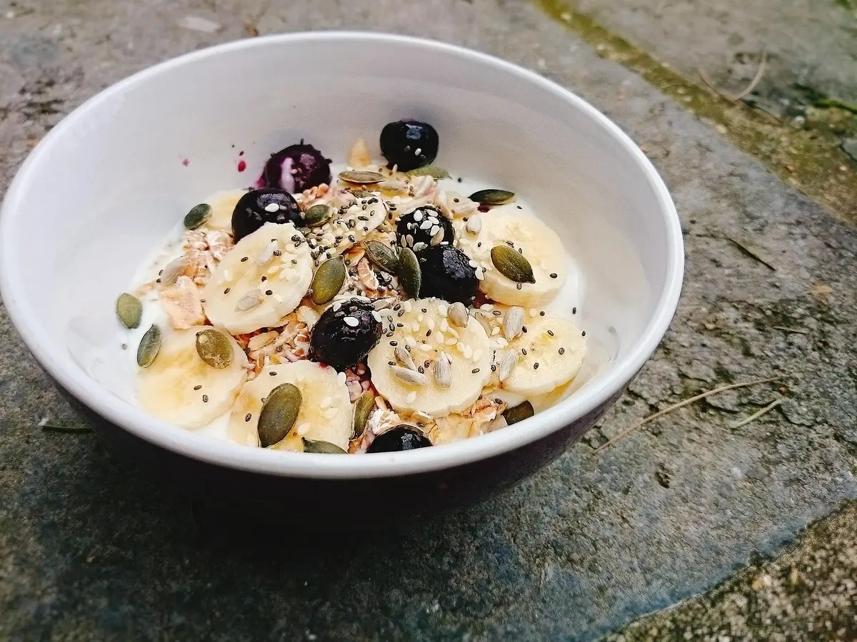 Petit déjeuner sain sur une table de cuisine en plein jour avec yaourt et légumes