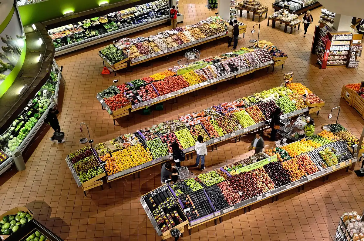 Personne faisant ses courses dans un supermarché, sélectionnant des fruits et légumes frais