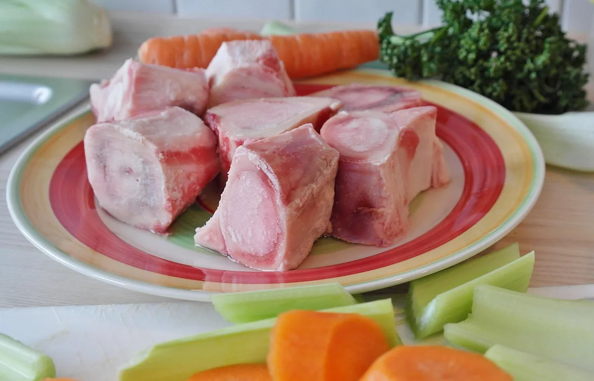 Peau de poulet et os sur une planche prêts à être cuits
