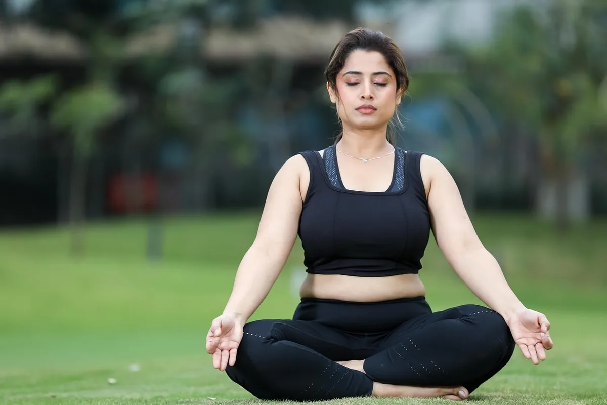 Personne assise près d'une fenêtre pratiquant une respiration profonde