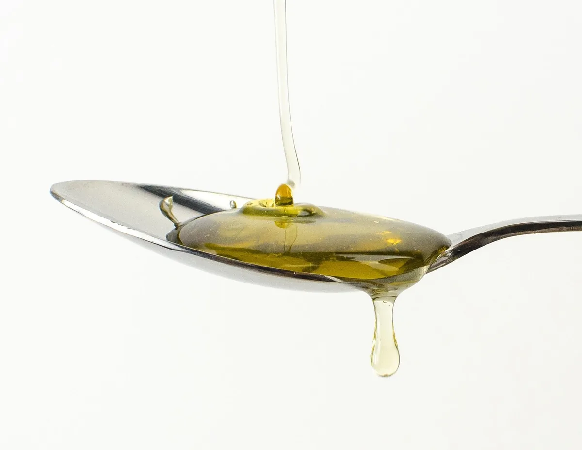 Pot de miel et flacon de sirop d'érable posés sur une planche en bois