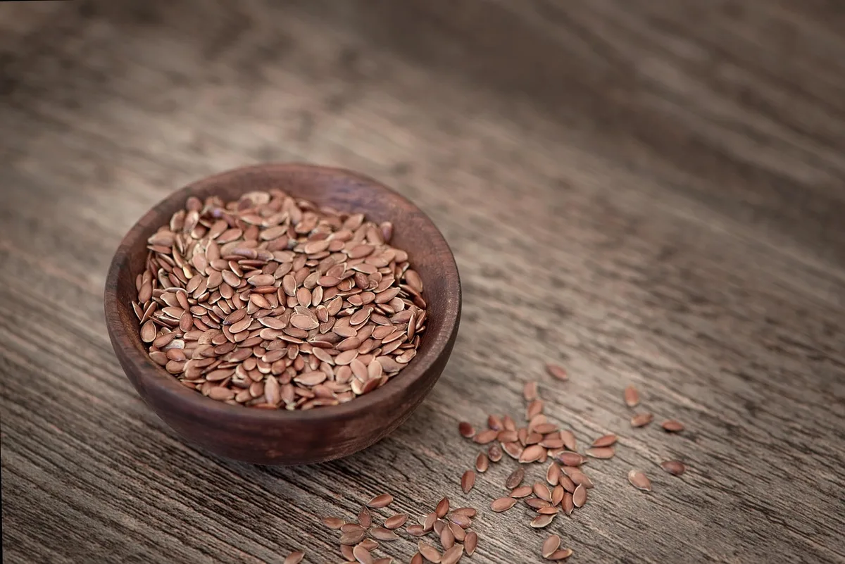 Grains de millet et farine disposés sur une surface, montrant texture et couleur