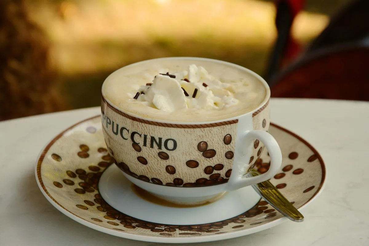 Tasse de café latte à la mousse onctueuse près d'une brique de lait d'avoine