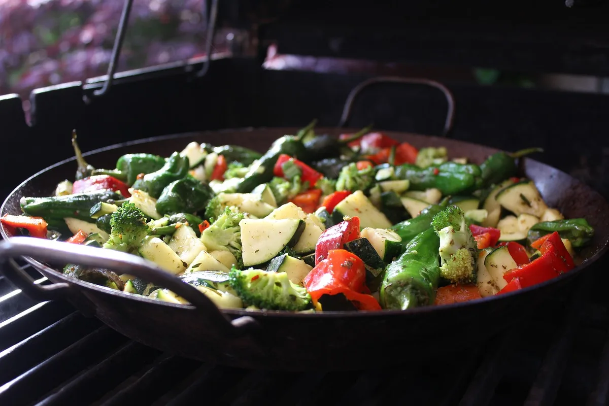 Bowl au saumon, quinoa et légumes fermentés posé sur une table ensoleillée